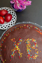 Chocolate Easter cake with the inscription XB and painted eggs