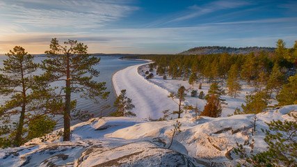 Fototapeta na wymiar panoramic view from the mountain to the winter beach and forest on the island of Koyonsaari in Lake Ladoga in Karelia