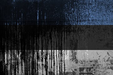 Estonia flag depicted in paint colors on old and dirty oil barrel wall closeup. Textured banner on...