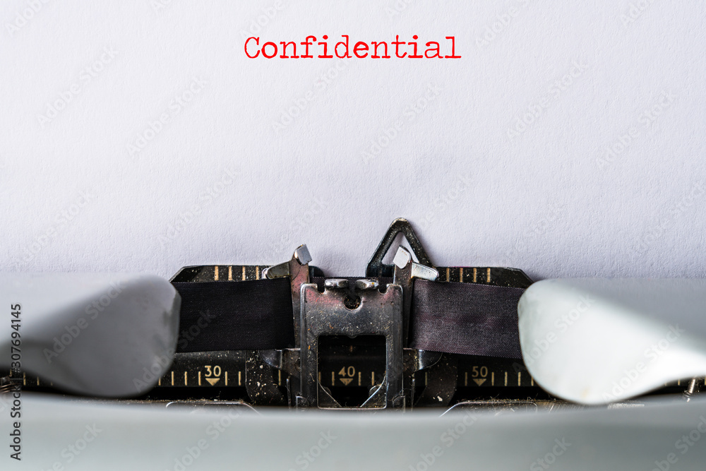 Fototapete closeup of old typewriter with the text confidential as header. copy space for own text on white pap