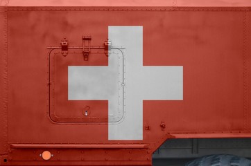 Switzerland flag depicted on side part of military armored truck closeup. Army forces conceptual...