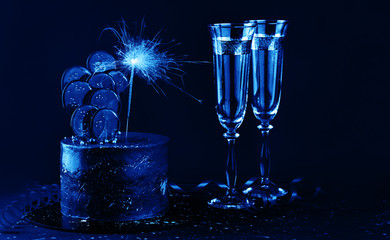 The festive cake is decorated with candies and sparklers. Holiday Content on a blue background