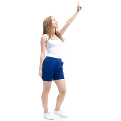 Woman in blue shorts and white shirt standing smiling showing pointing on white background isolation