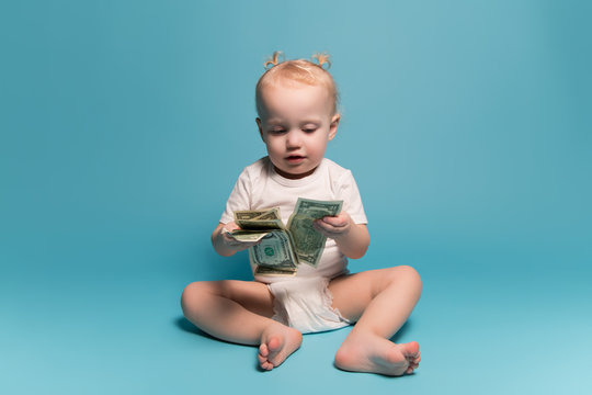baby girl counts the dollars that she holds in her hands. Close-up