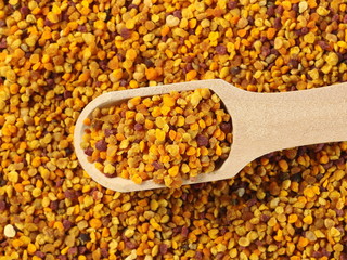 Pollen in wooden spoon background and texture