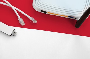 Indonesia flag depicted on table with internet rj45 cable, wireless usb wifi adapter and router....