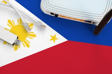 Philippines flag depicted on table with internet rj45 cable, wireless usb wifi adapter and router....