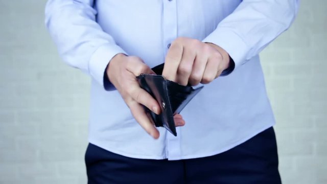 Bankruptcy - Business Person holding an empty wallet. Man showing empty wallet