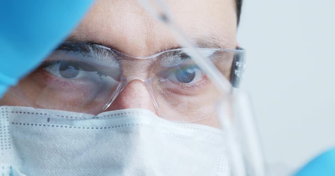 Technician carefully drips the solution from the pipette into glass tubes for DNA analysis.
