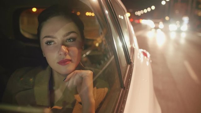 Young brunette Businesswoman in the taxi is reading messages on her tablet