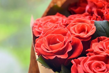 Red roses background. Bouquet beautiful red roses with selective focus in craft paper. Luxury bouquet made of amazing red roses. Valentines Bouquet of red roses. Present for Mother’s Day. 