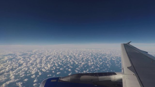 Airplane flying through clouds, over wing window view