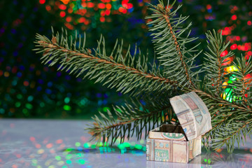 Open chest with gifts. Against the background of a fir branch and rainbow bokeh.