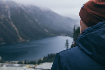 man looking at a mountain lake
