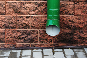 Water Draining Gutter Downpipe on a brown wall