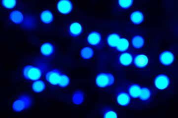 blurred night classic blue color glowing lights on black background. new year and christmas concept. color 2020