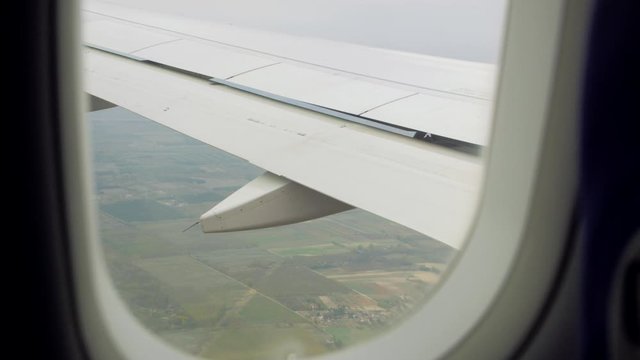 Wing flaps of the airplane turbulence window aerial view