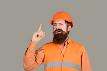 Man builder having good idea. Builder in protective clothing and helmet. Engineer warns of danger lifting his finger up. Man builder in hard hat shows warning sign with finger. Builder in hardhat.