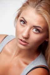 Fototapeta premium Young beautiful girl with blond long hair looks straight.