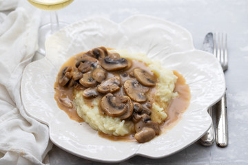 mashed potato with mushrooms and sauce on white dish