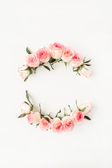 Round frame border of pink rose flower buds on white background. Mockup blank copy space. Flat lay, top view floral composition.