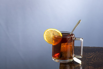a mug of lemon tea with a falling slice of sugar and a splash from its fall
