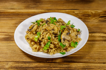 Tasty risotto with mushrooms on wooden table