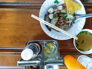 Dry pork noodles with a drink on a wooden table