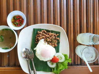 Pork fried rice and fried egg with a drink on the wooden table, top view