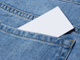 A business card is visible from the pocket of his jeans. Copy and text space