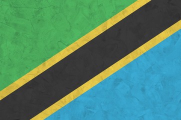 Tanzania flag depicted in bright paint colors on old relief plastering wall. Textured banner on...