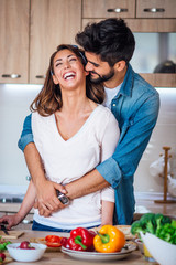 Happy couple showing affection in the kitchen.