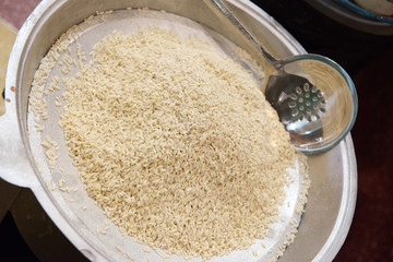Many grains of rice in a large metal bowl.