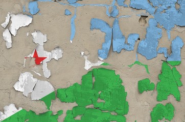 Djibouti flag depicted in paint colors on old obsolete messy concrete wall closeup. Textured banner...