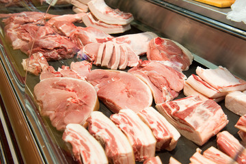 Sliced ​​raw meat behind the counter in the store.