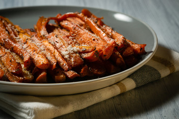 Fried carrots  on a plate. Cooked sliced of sauteed vegetables.