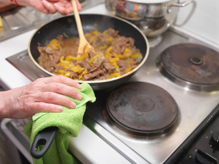 hand holding hot handle of a cooking pan
