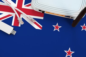 New Zealand flag depicted on table with internet rj45 cable, wireless usb wifi adapter and router....