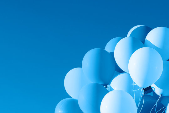 Color of 2020 year, classic blue. Group of balloons with helium on the sky background. Trend color.