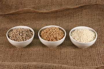 Three bowls with buckwheat, rice and sunflower seeds