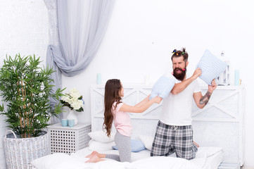 Obraz na płótnie Canvas Happy family. Role of father. Pillow fight. Dad seeks to live life of integrity and honesty. Sincere emotions. Dad and daughter having fun. Pajamas party. Happy childhood. Upbringing happy daughter