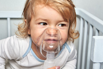 Little white girl is breathing with nebulizer.