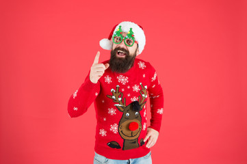 Winter presentation. Happy new year celebration. Join holiday celebration. Party outfit. Sweater with deer. Hipster bearded man wear winter clothes red background. Christmas celebration ideas