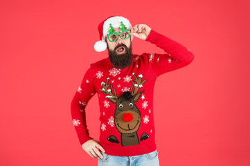 Winter party outfit. Sweater with deer. Hipster bearded man photo booth props red background. Christmas celebration ideas. Winter style. Happy new year celebration. Join holiday celebration
