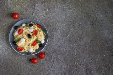 tasty pasta with red tomatoes, olives and mozarella
