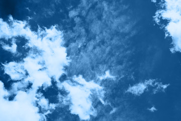 Fototapeta premium White fluffy clouds in a bright blue sky on a sunny day.