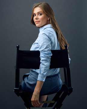 Woman With Long Hair  Sitting Back On Movies Director Chair Turns To  Side.