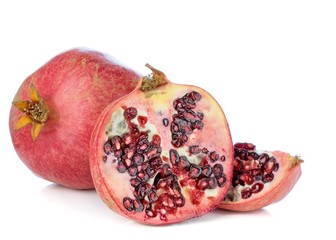 A close up of a pomegranate fruit cut in half showing the seeds on a white background