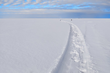 Path under a turquoise sky through a snowy field. The horizon between the sky and the snow field divides the frame in a ratio of one to four. You can place the text below.
