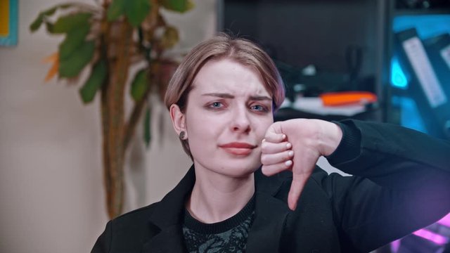 A young woman showing thumb down sign to dislike